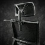 Black ergonomic mesh office chair featuring an adjustable headrest and breathable back support for comfortable long-hour office work.